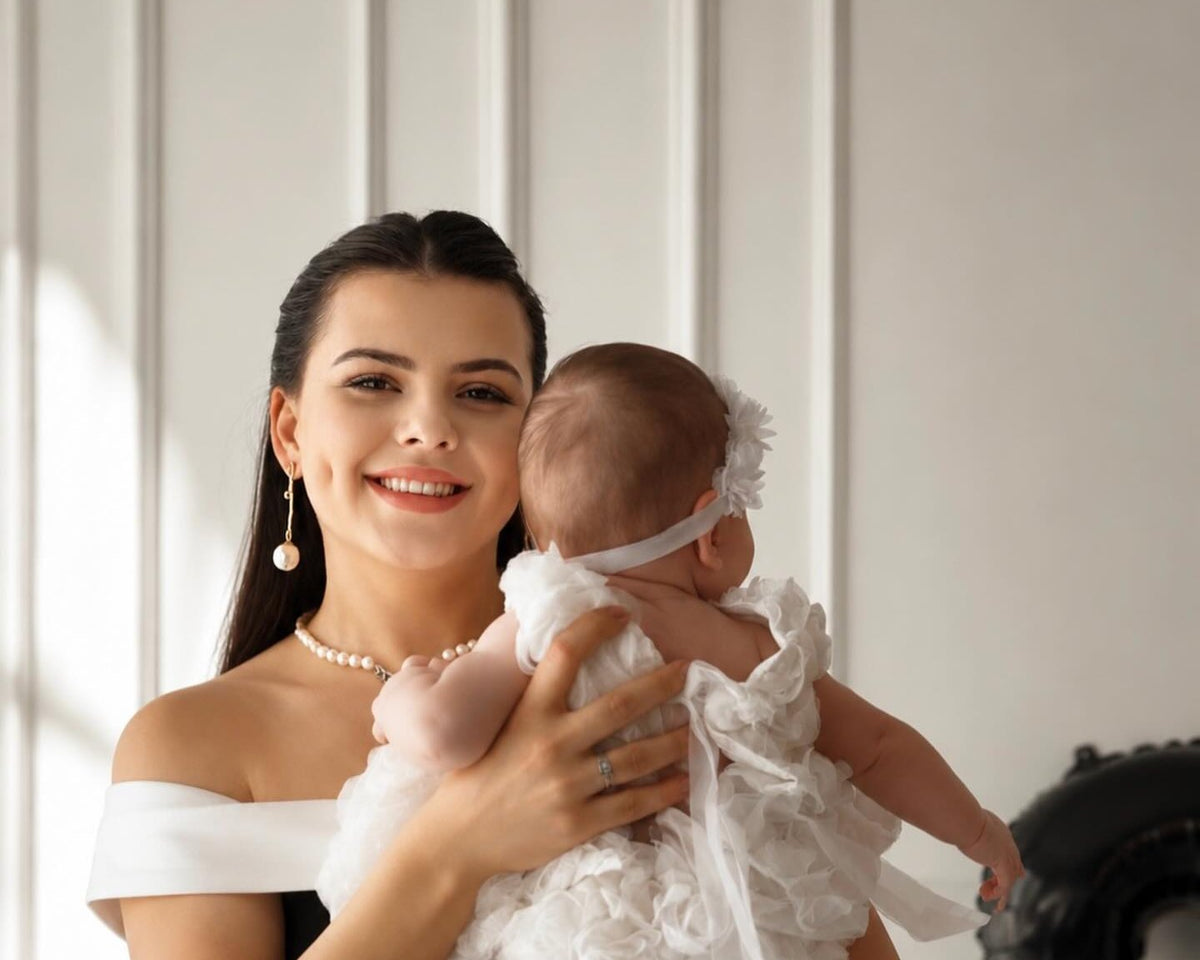 Bebeğini kucağında tutan gülümseyen anne